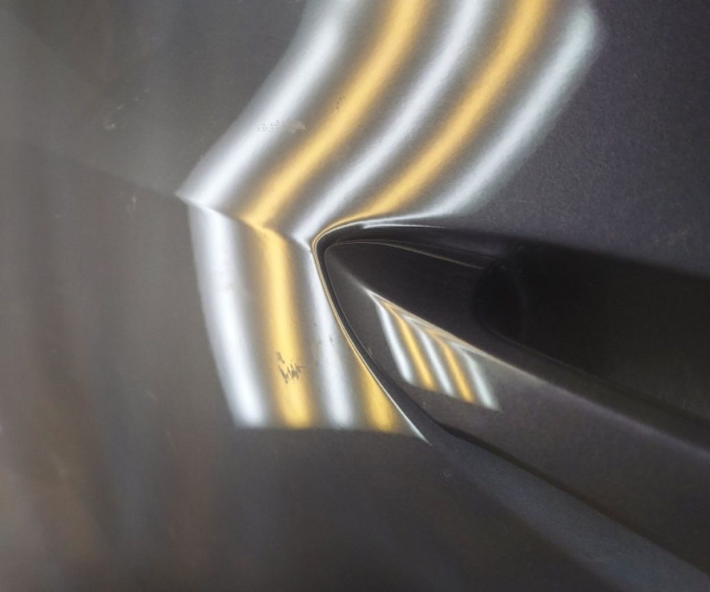 The same door panel smooth beside the handle after paintless dent repair