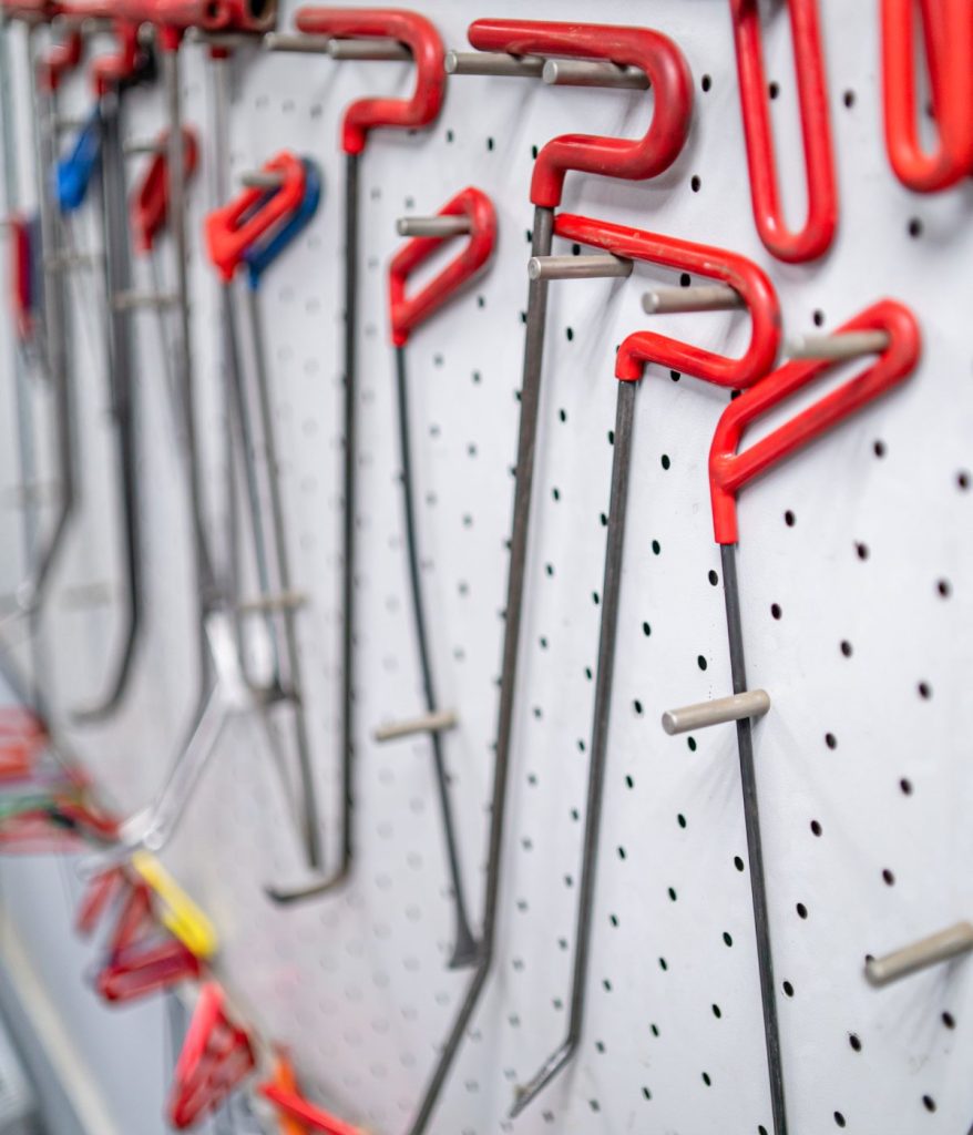 Paintless dent repair rods hanging on a pegboard