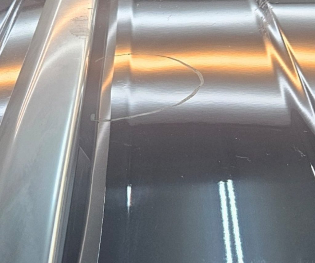 The same car roof with straight reflection lines after paintless dent repair
