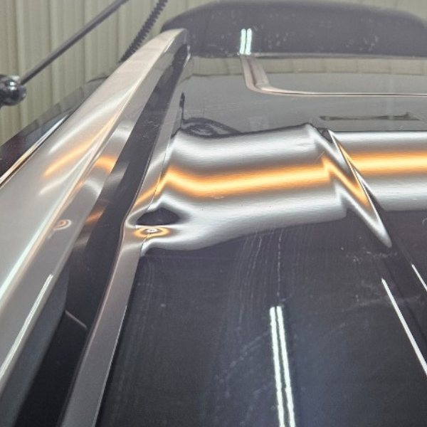 Reflection lines bending around a dent in a car roof